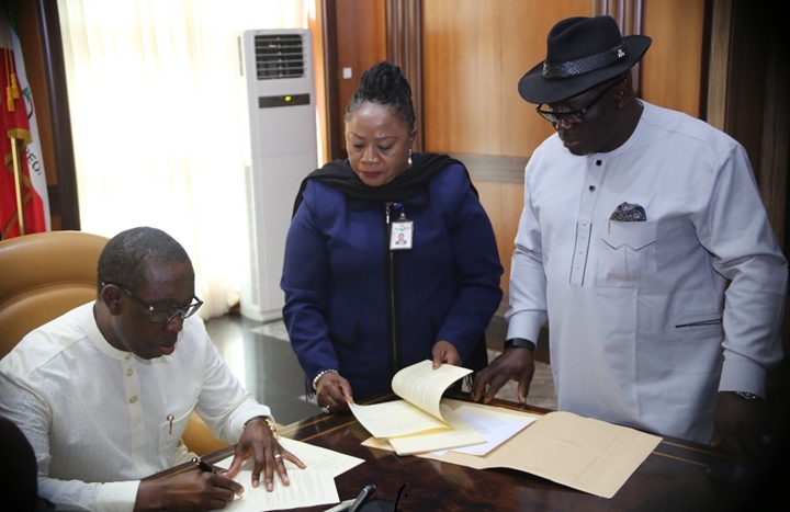 Delta State Governor, Senator Ifeanyi Okowa (left), assisted by the Speaker of the State House of Assembly, Rt Hon Sheriff Oborevwori (right), and the Clark of the House, Mrs Lyna Ocholor, signing into Law, the Delta State Public and Private Properties Bill, 2018 and the Delta State Oil Producing Areas Development Commission (Amendment) Bill, 2018.