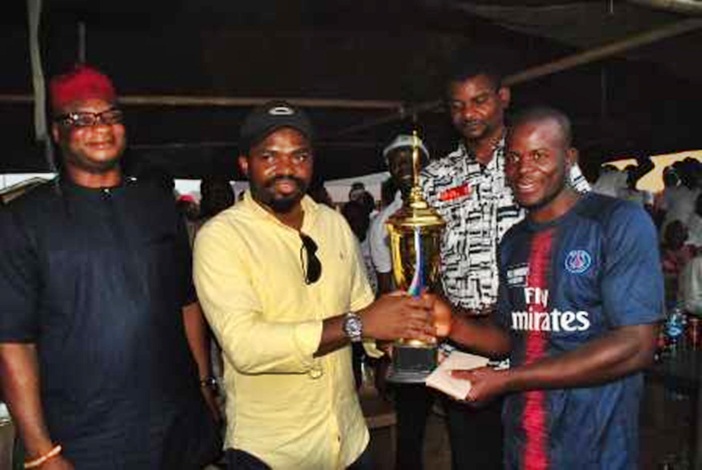 Engr. Fidel Onwodi presenting the Football Trophy to the Winning Team