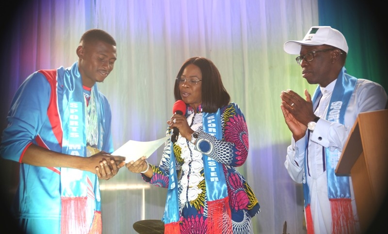 Delta State Governor, Senator Ifeanyi Okowa (right), watching as his wife Dame Edith presents certificate and Cheque to a Gold medalist, Mr Nmor Ifeakachukwu at the Reception/Award of Athletes and Officials to the 4th National Youth Games 2018 and the 19th National Sports Festival, Abuja, in Asaba.