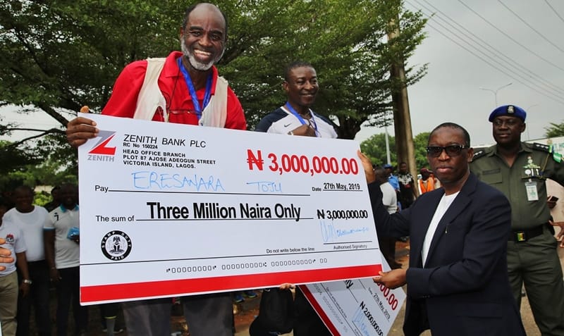 Delta State Governor, Senator Ifeanyi Okowa (right) presenting a cash price to the 1st winner of Governor’s Annual Elders Tournament Walk 2019, 10 KM Walk, Eresanara Toju, held in Asaba Delta state.