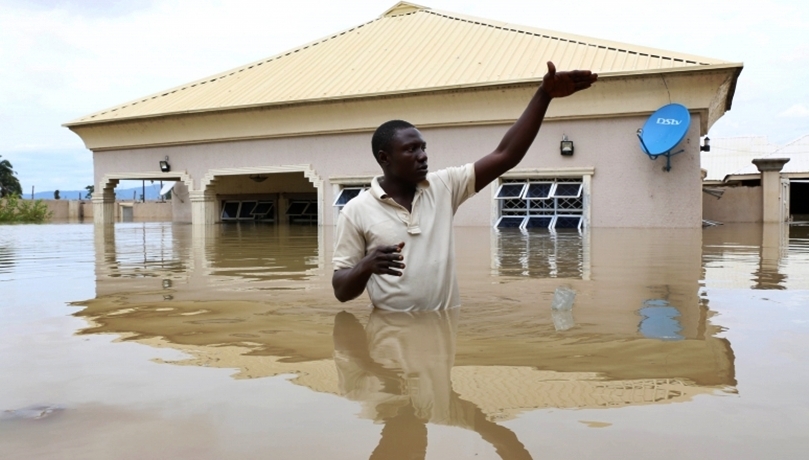 A Man Standing in a Flood Ravaged Compound