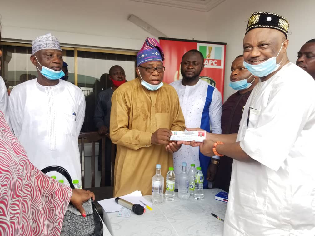 Chief Great Ogboru (right) receiving his membership card from the Chairman of the Delta state Revalidation team, Surveyor Abiodun in Abraka, Ethiope East, Delta state on Thursday, March 4, 2021
