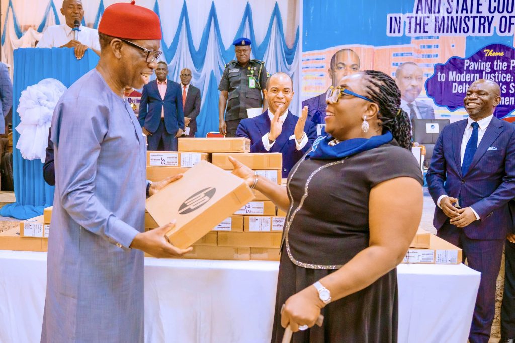 Delta Governor, Senator Dr. Ifeanyi Okowa (left), presenting a laptop computer to Barr. Mene Tosan as the Commissioner for Justice and Attorney General, Isaiah Bozimo claps at an interactive session between the Governor and State Counsels in Asaba on Tuesday, March 28, 2023. (Pix: twitter.com/aiokowa)