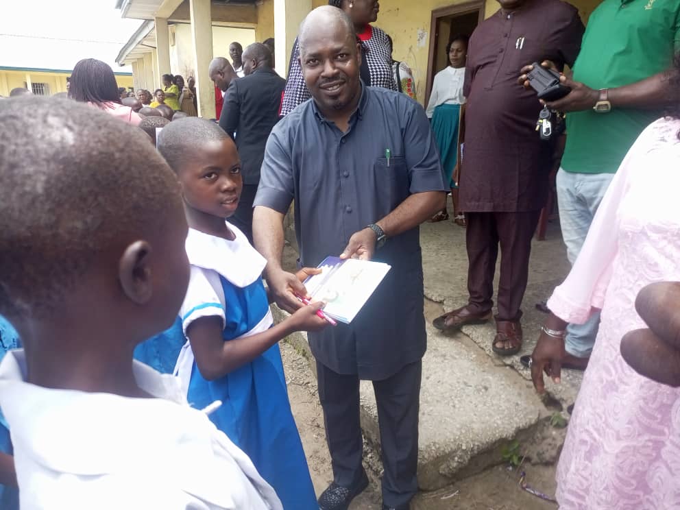 Victor Ofobrukueta Ethiope East Chairman presenting educational materials to Pupils