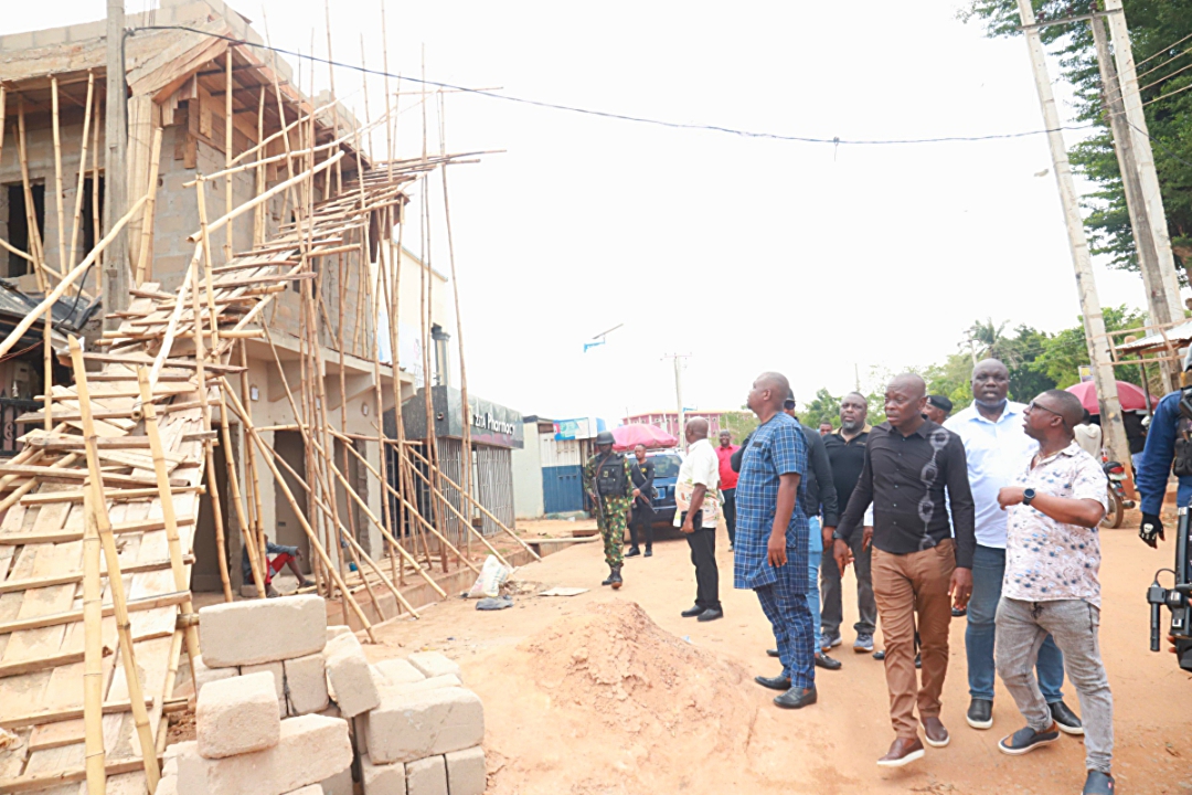 Chairman of Delta Taskforce on Recovery of Govt Lands, Chief Frank Omare ( 2nd right) takes a look at an illegal structure on an encroached land belonging to the state government during the inspection of government lands around Dennis Osadebay University, Asaba by members of the Taskforce