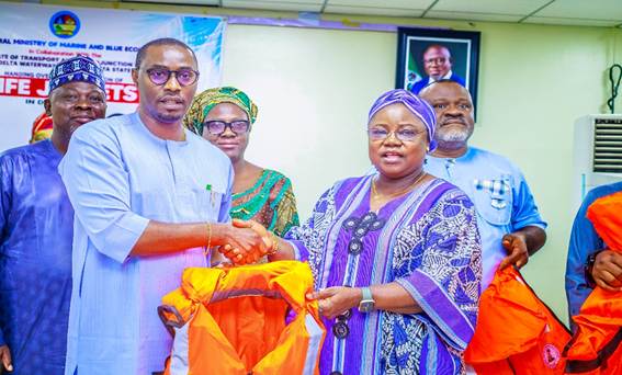 From the right Dr. Mercy Ilori, the representative of the Honorable Minister of Marine and Blue Economy Adegboyega Oyetola presenting the life jacket to Mr. Onoriode Agufure Honorable Commissioner Directorate of Transport.