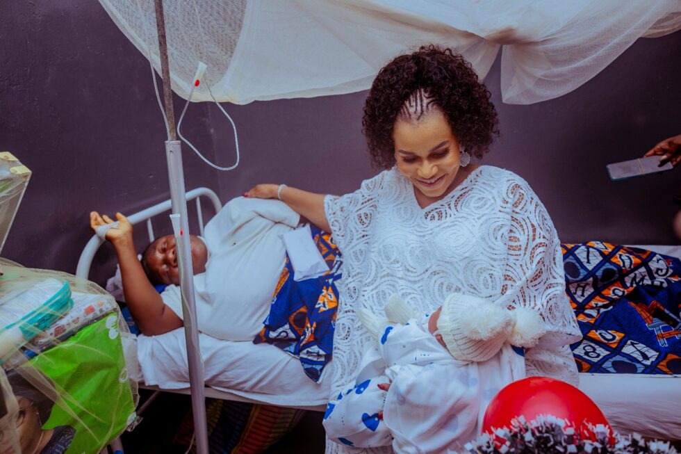 Deaconess Tobore Oborevwori carrying the Baby of the New Year 2026 in Delta State, as the mother lies down watching.