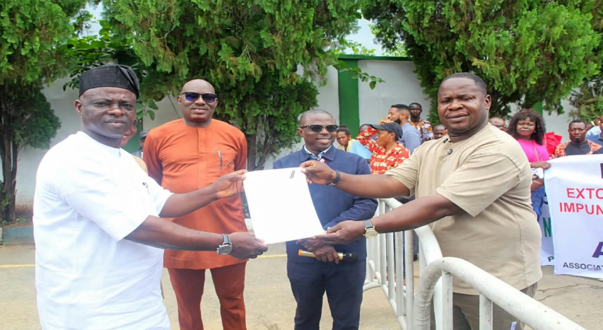 Delta State Commissioner Bureau for Special Duties, Mr. Etagherure Terry (left), receiving a document from the Chairman, Association of Table Water Producers (ATWAP) Delta State Chapter, Mr. Mark Evans, during a peaceful protest against extortion by officials of the Standard Organization of Nigeria (SON) in Asaba on Thursday, while the Executive Assistant To The Governor On Public Service Matters, Sir Augustine Oghoro, (2nd right), and the E.A on Public Enlightenment (Projects and Policies) Sir Olisa Ifeajika look on.